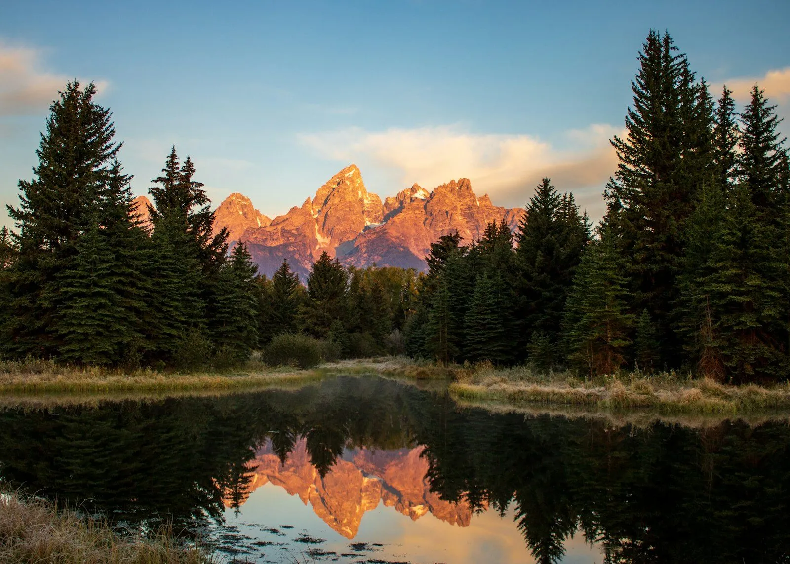 The Teton Range at sunrise reflected in still water at Schwabacher Landing